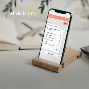 Smartphone displaying an alive Listens market research chat on a desk.